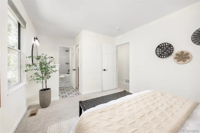 a bedroom with a bed and a potted plant