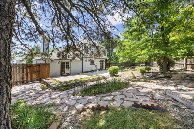 a view of a back yard with patio and a garden