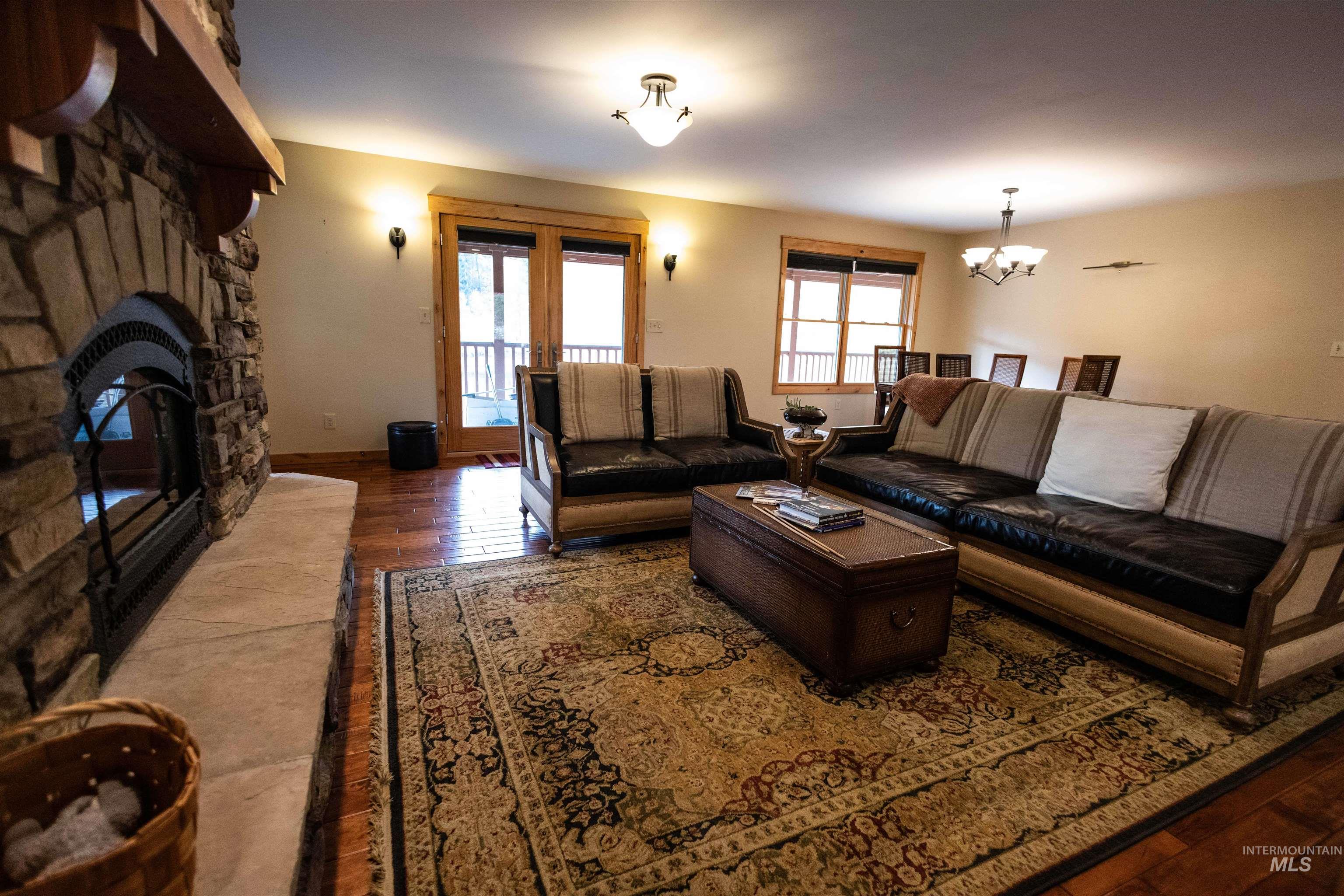 4480 Highway 12 Kamiah, ID 83536 - Photo 24 of 49 Living area featuring hardwood / wood-style floors, a fireplace, plenty of natural light, and a chandelier