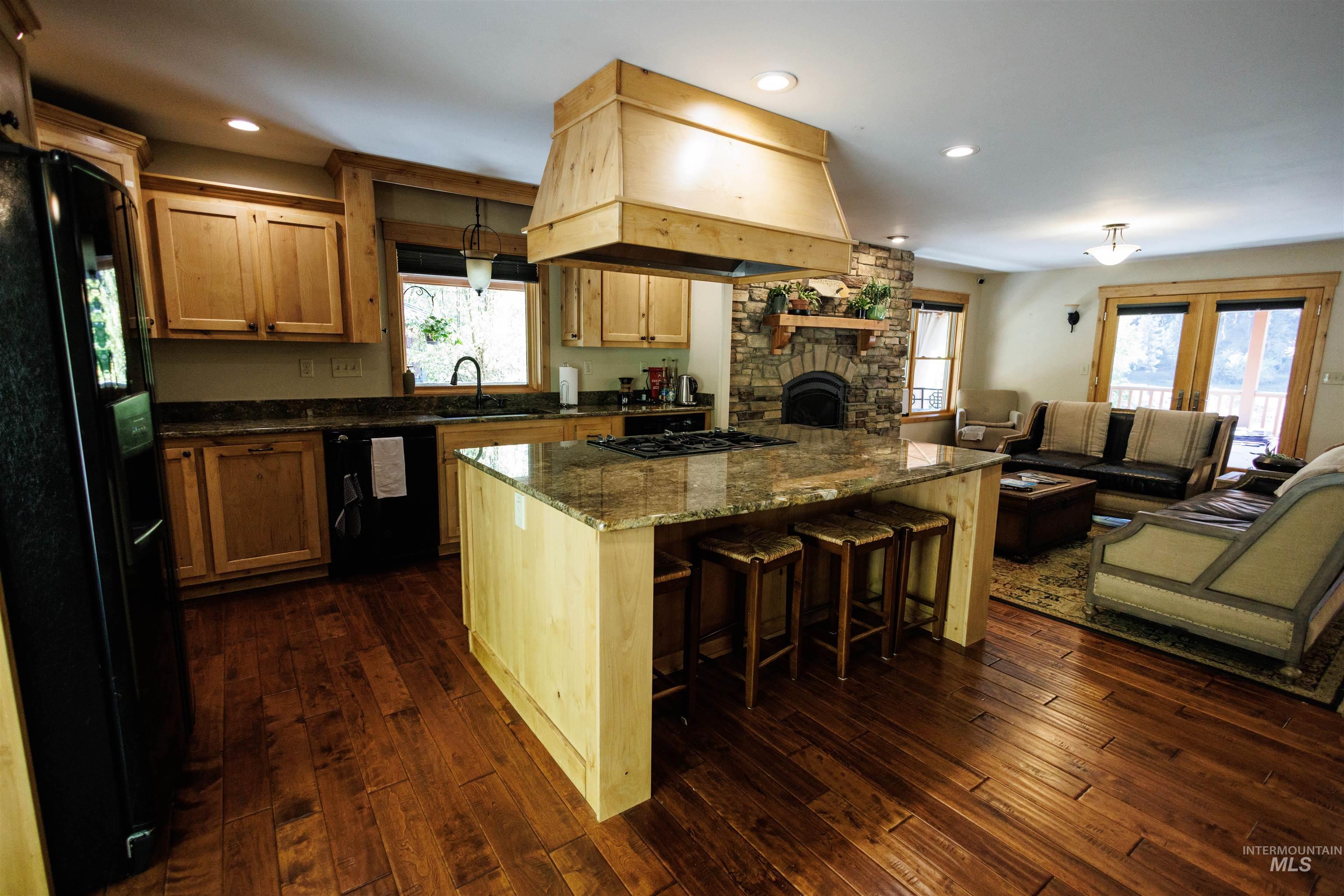 4480 Highway 12 Kamiah, ID 83536 - Photo 49 of 49 Kitchen with black appliances, premium range hood, dark wood-style floors, open floor plan, and recessed lighting