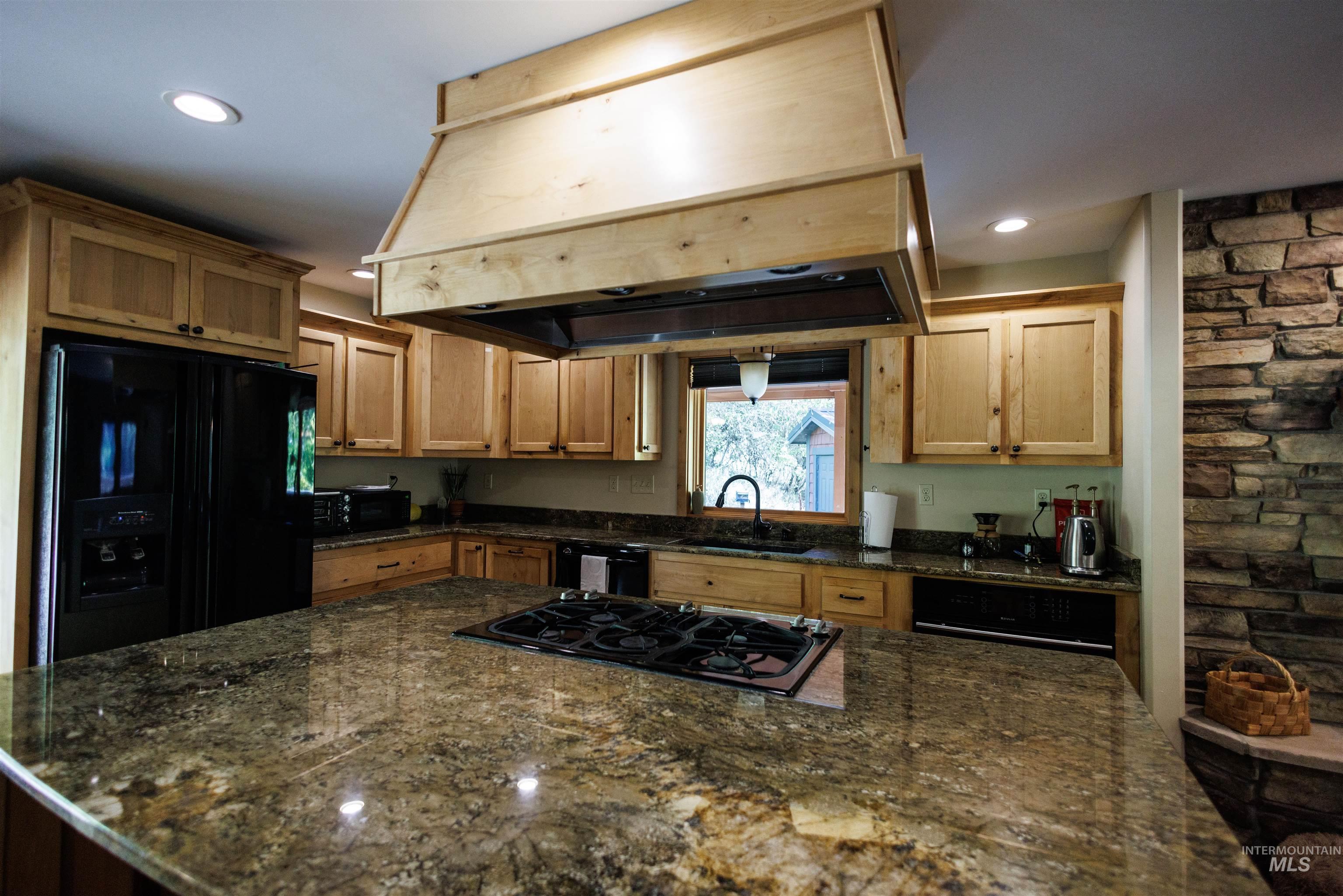 4480 Highway 12 Kamiah, ID 83536 - Photo 27 of 49 Kitchen with custom range hood, black appliances, dark stone countertops, recessed lighting, and a center island