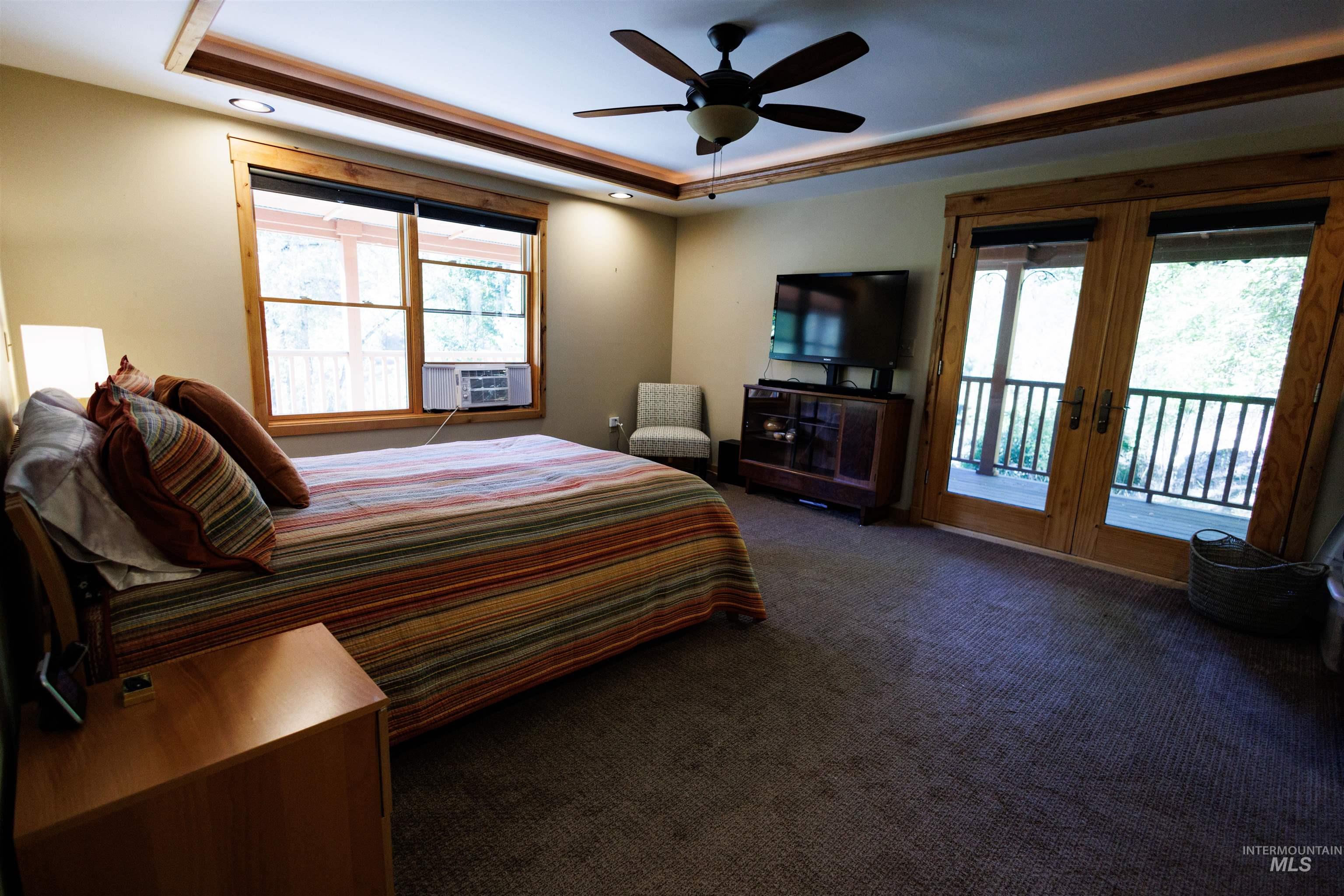 4480 Highway 12 Kamiah, ID 83536 - Photo 31 of 49 Bedroom featuring a tray ceiling, multiple windows, carpet, and access to outside