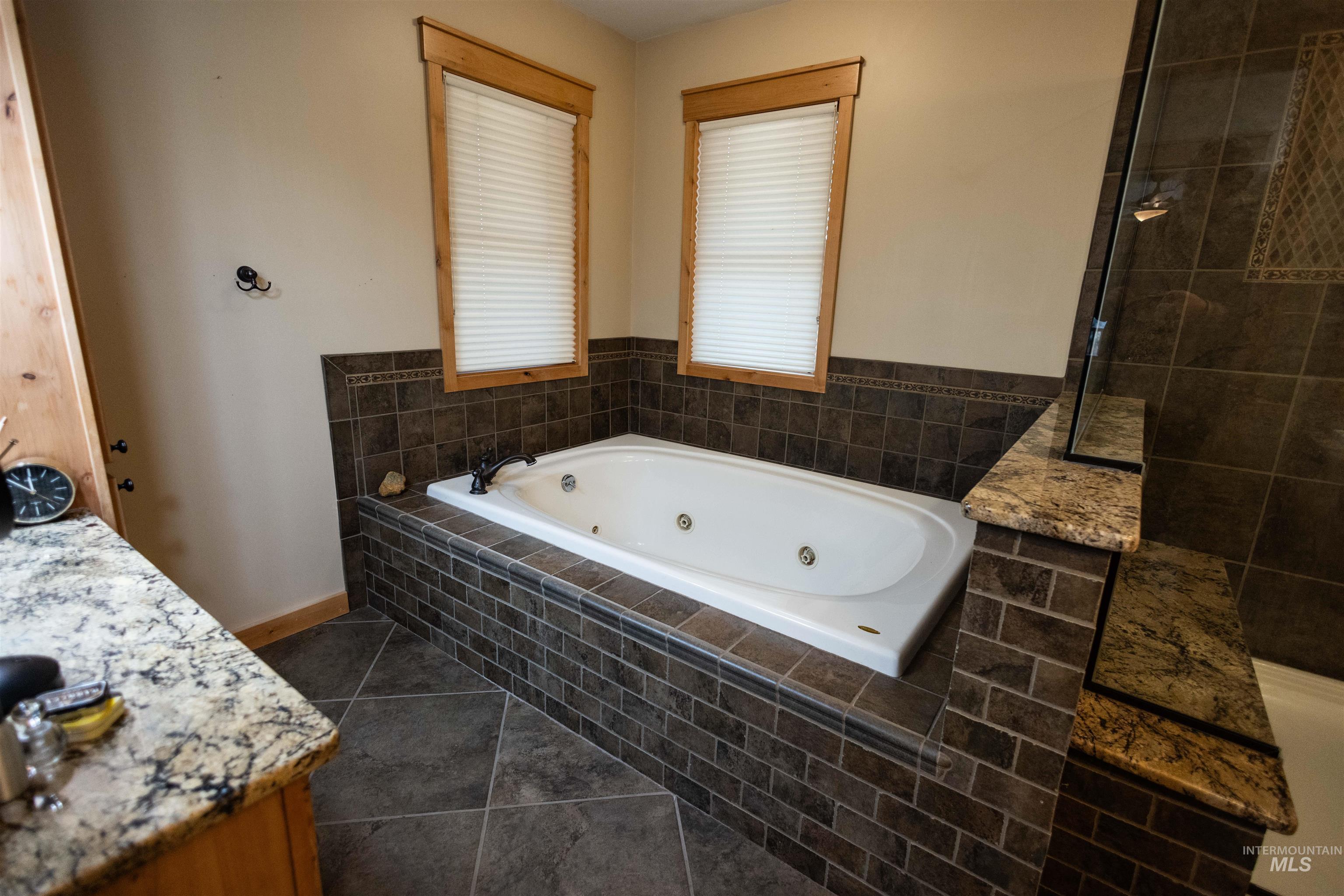 4480 Highway 12 Kamiah, ID 83536 - Photo 35 of 49 Full bath featuring a whirlpool tub, dark tile patterned floors, and vanity