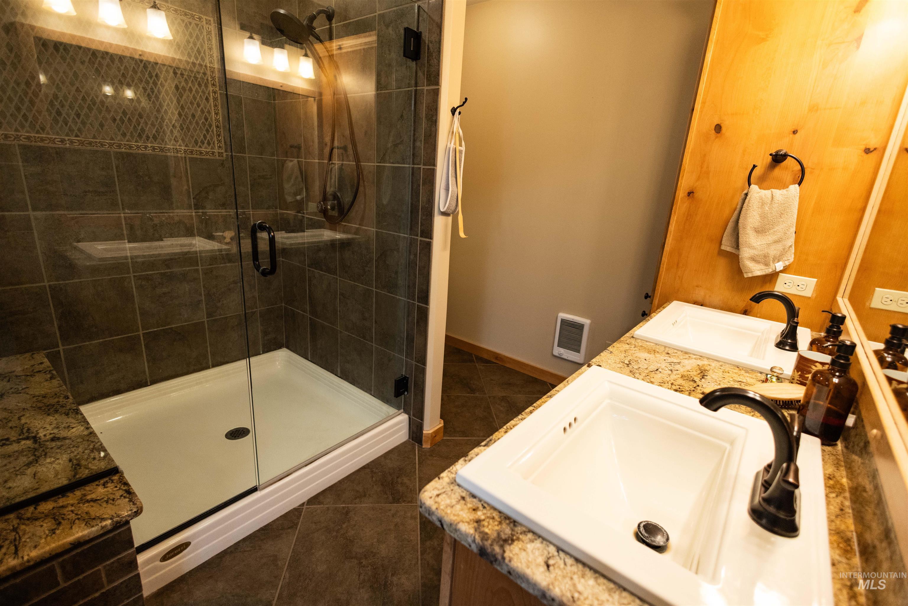 4480 Highway 12 Kamiah, ID 83536 - Photo 36 of 49 Full bath featuring double vanity, a shower stall, and dark tile patterned flooring