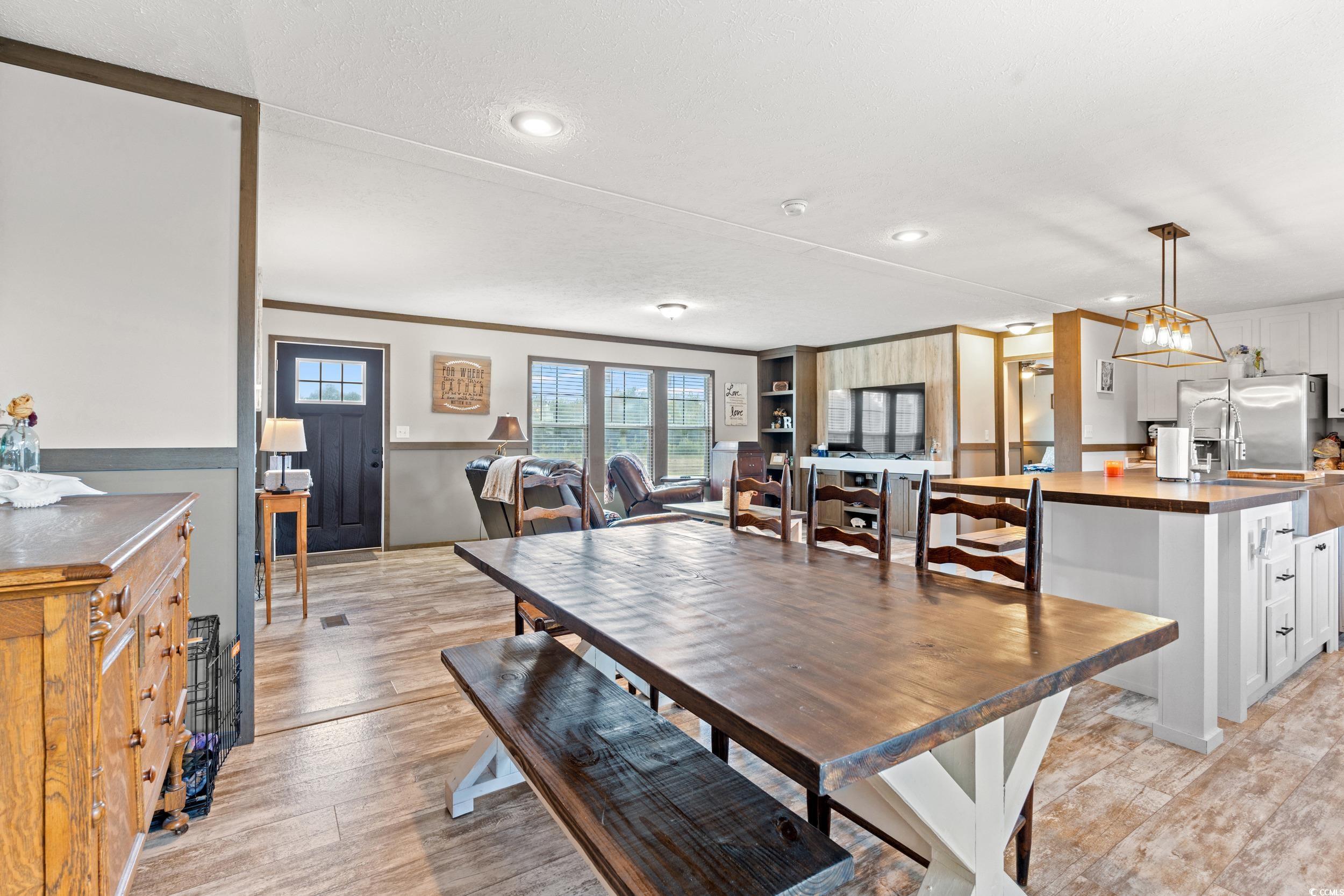Dining space with crown molding, light wood-type flooring, and recessed lighting
