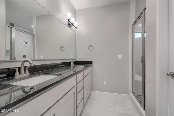 a bathroom with a granite countertop sink and a mirror