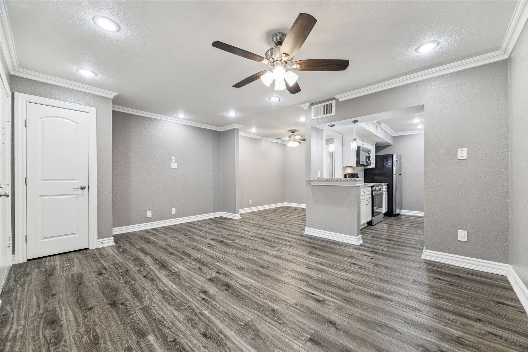 11550 Chimney Rock Road, Unit 321 Houston, TX 77035 - Photo 4 of 10 a view of an empty room with wooden floor and a ceiling fan