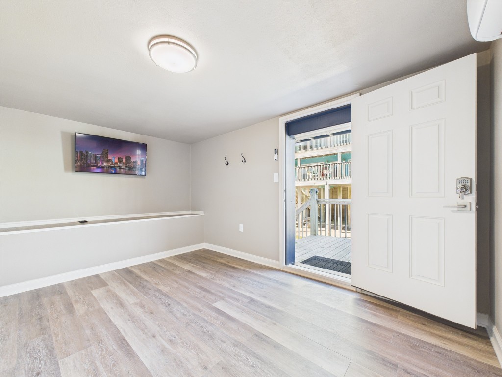 842 Main Street Crystal Beach, TX 77650 - Photo 14 of 45 an empty room with wooden floor and windows