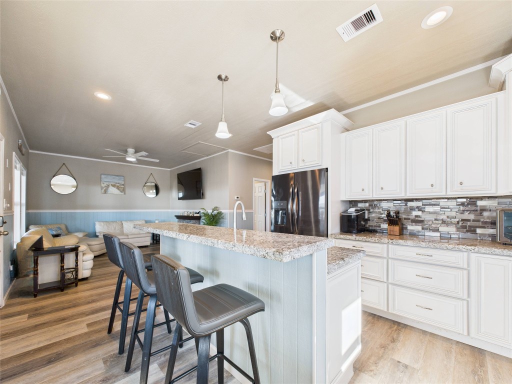 842 Main Street Crystal Beach, TX 77650 - Photo 25 of 45 a kitchen with stainless steel appliances kitchen island granite countertop a table chairs and a refrigerator