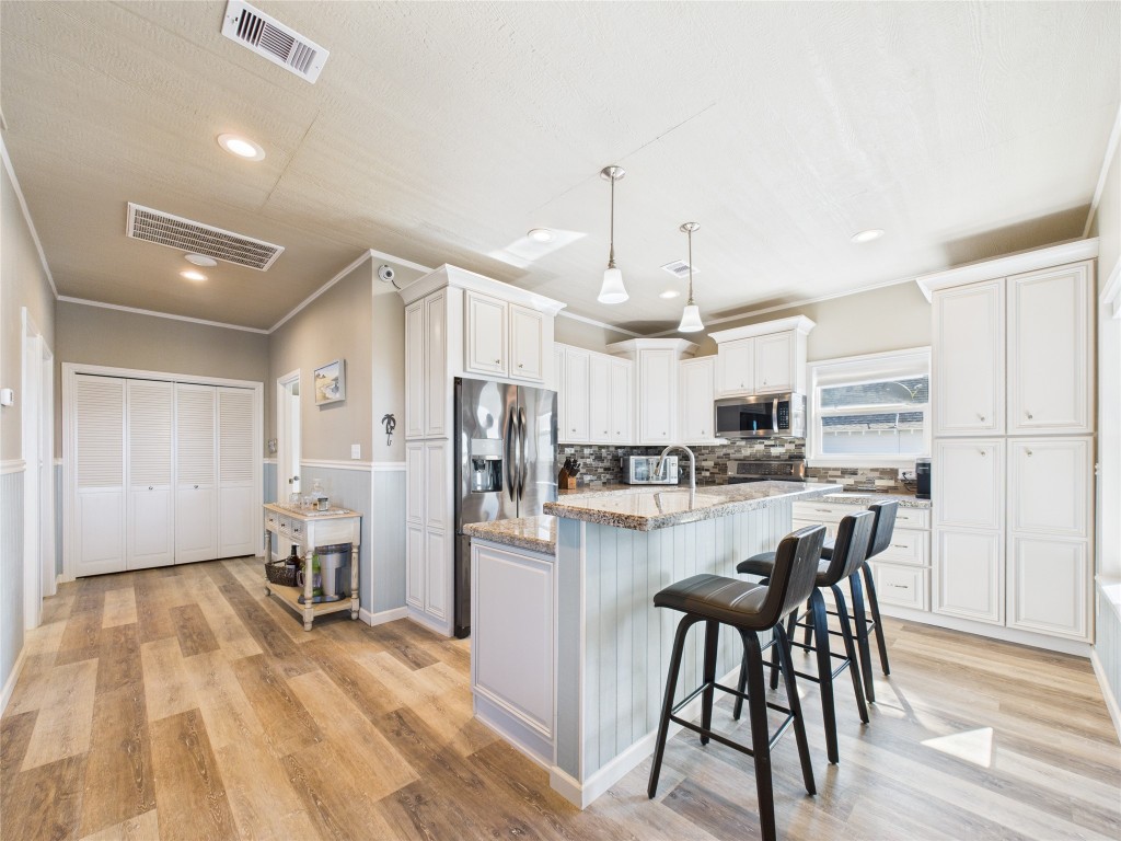 842 Main Street Crystal Beach, TX 77650 - Photo 29 of 45 a view of kitchen with refrigerator and wooden floor