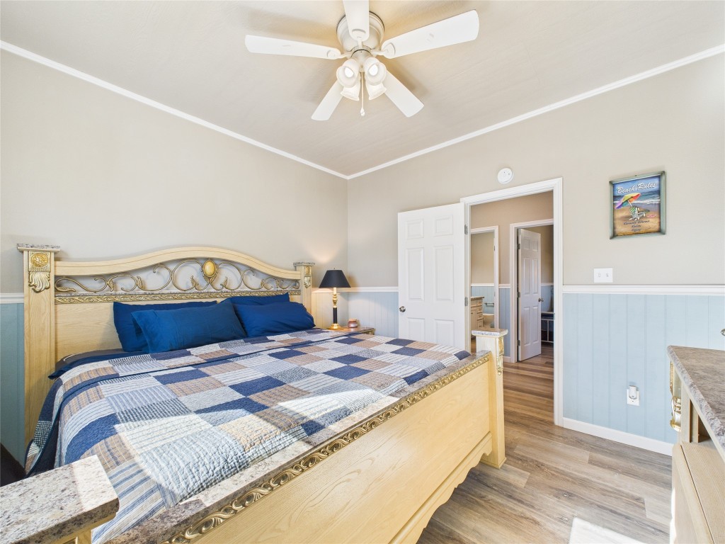 842 Main Street Crystal Beach, TX 77650 - Photo 33 of 45 a bedroom with a bed and a chandelier