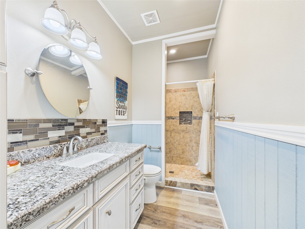 842 Main Street Crystal Beach, TX 77650 - Photo 37 of 45 a bathroom with a granite countertop sink a toilet and shower