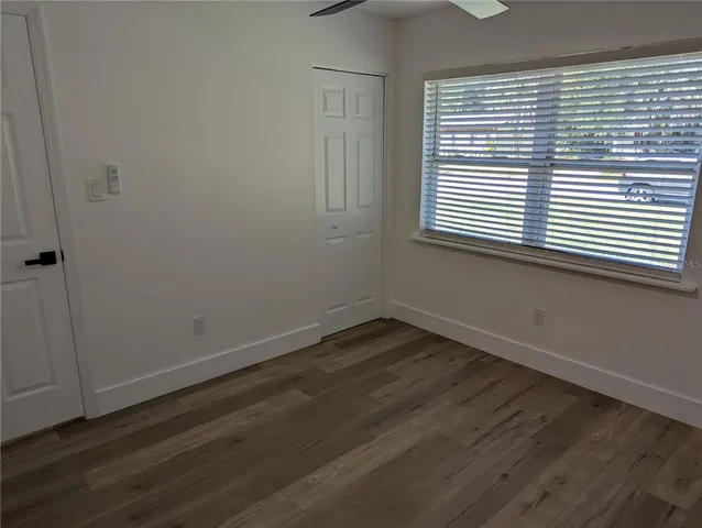 an empty room with wooden floor and a window
