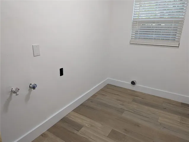a view of a small space with wooden floor and a window