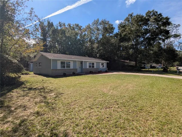 a view of house with garden and tall trees