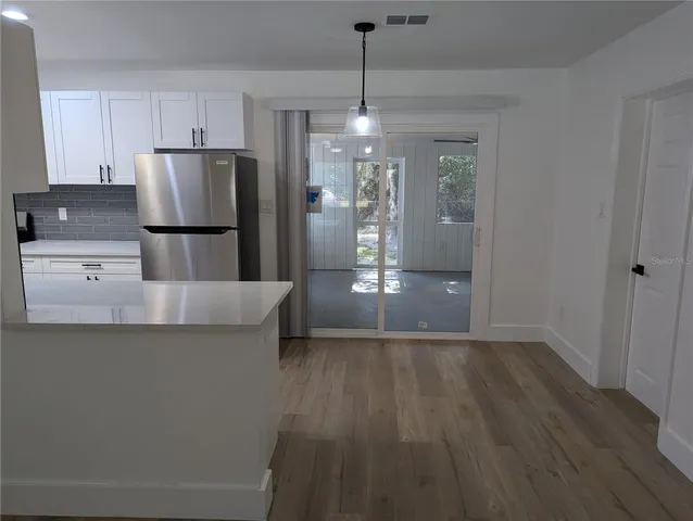 a kitchen with kitchen island a counter top space stainless steel appliances and cabinets