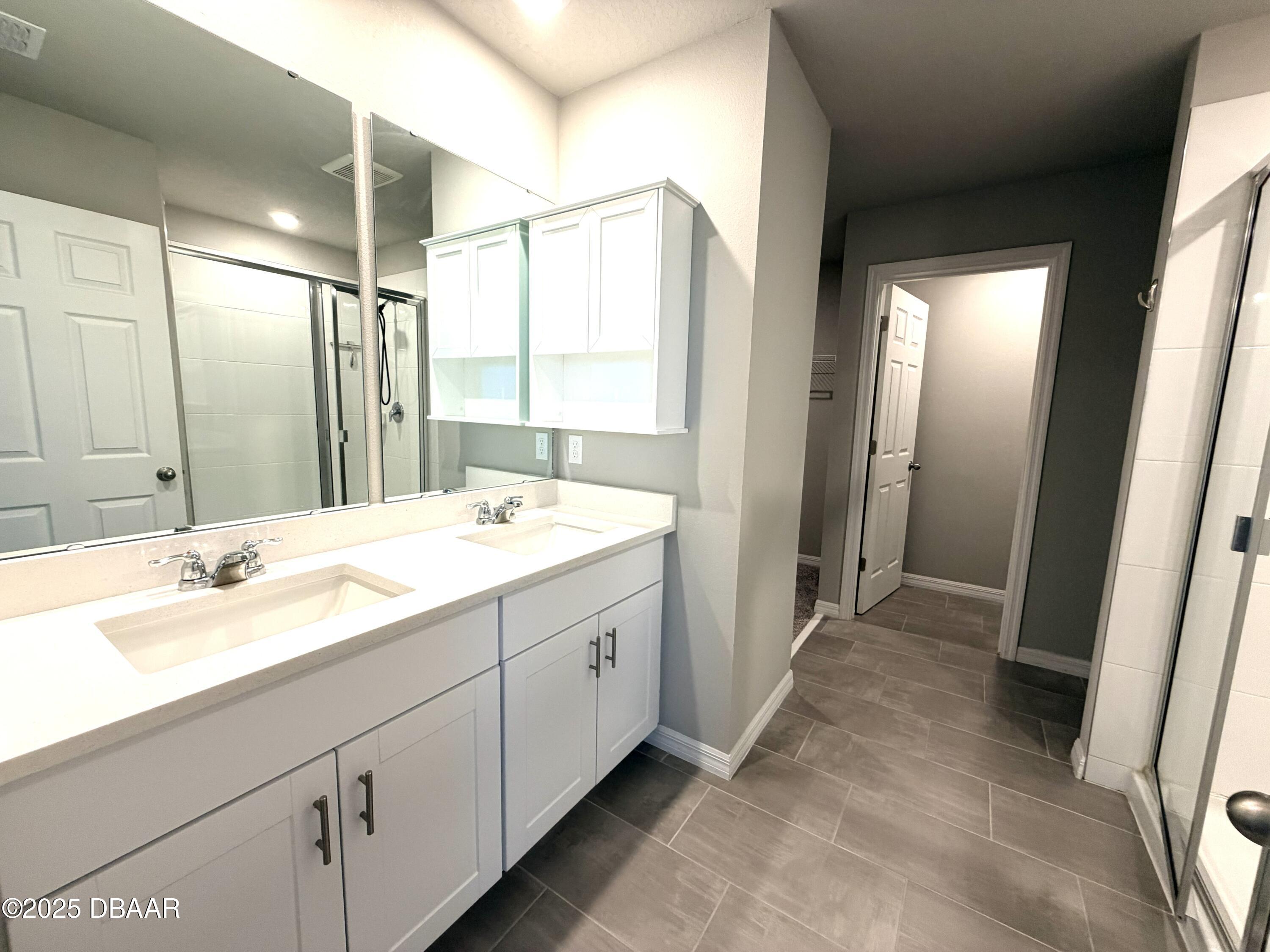 30224 Armenia Road Leesburg, FL 34748 - Photo 14 of 29 a bathroom with a double vanity sink and mirror