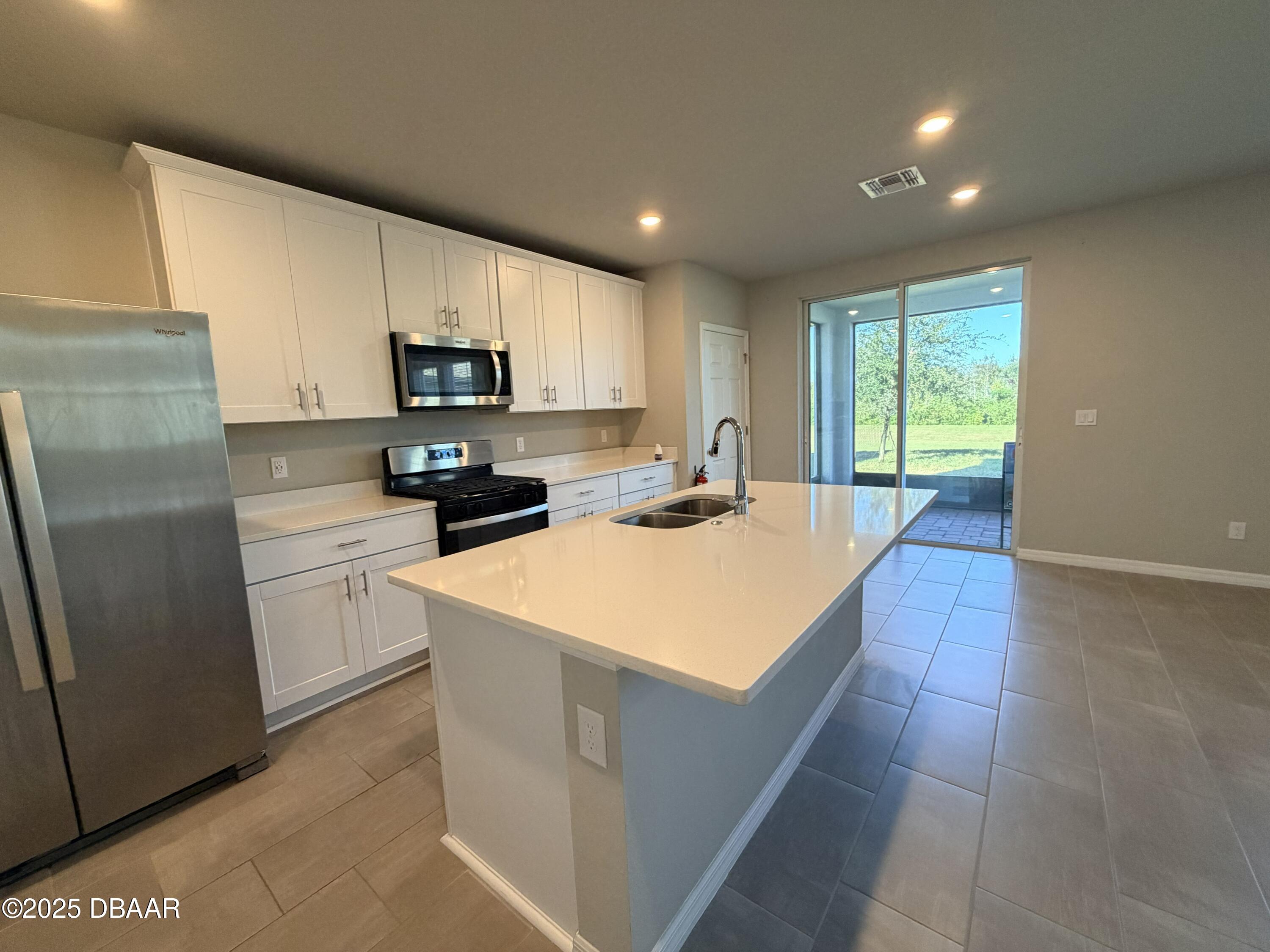 30224 Armenia Road Leesburg, FL 34748 - Photo 5 of 29 a kitchen with stainless steel appliances a refrigerator sink microwave and stove