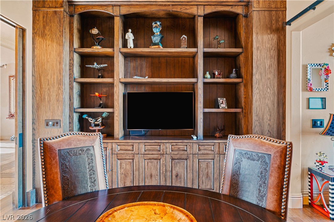 1123 Christian Road Henderson, NV 89002 - Photo 40 of 94 Rich wood built-in shelving offers both storage and display space, framing a versatile entertainment area.