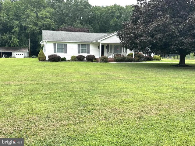 a view of a house with a big yard and large trees