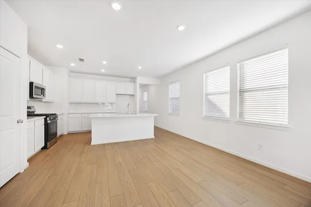 a large kitchen with stainless steel appliances kitchen island a large counter top and a stove top oven