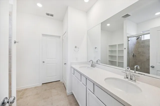 a spacious bathroom with a shower sink and mirror