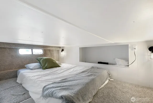 a bedroom with a large bed and a lamp with the wall