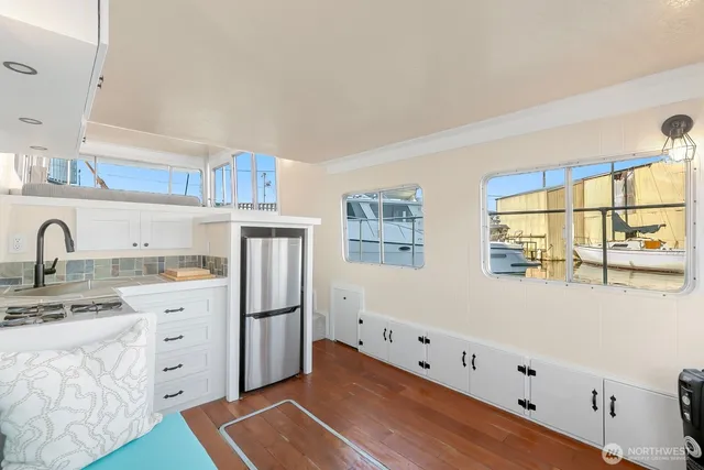 a kitchen with white cabinets and window