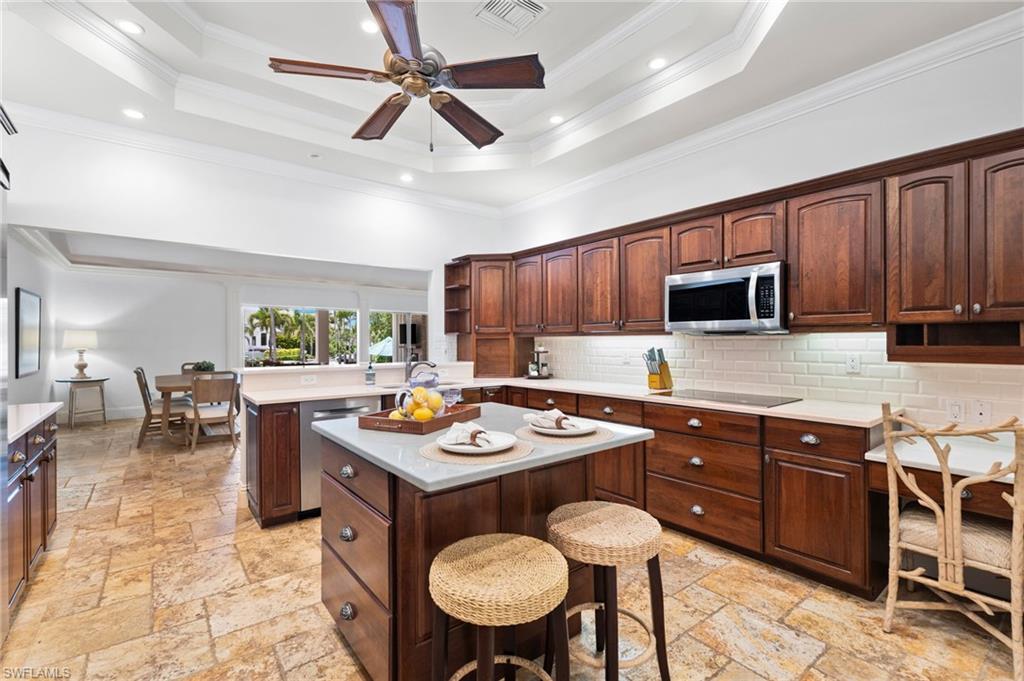 2201 Beacon Lane Naples, FL 34103 - Photo 14 of 25 a kitchen with a cabinets appliances and a dining table
