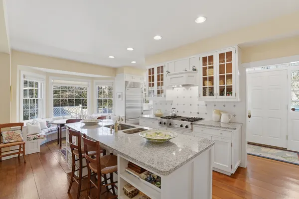 a view of a kitchen with granite countertop a sink and chairs