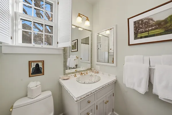 a bathroom with a sink a toilet and a mirror