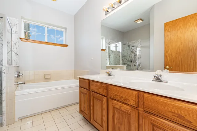 a bathroom with a granite countertop sink mirror and bathtub