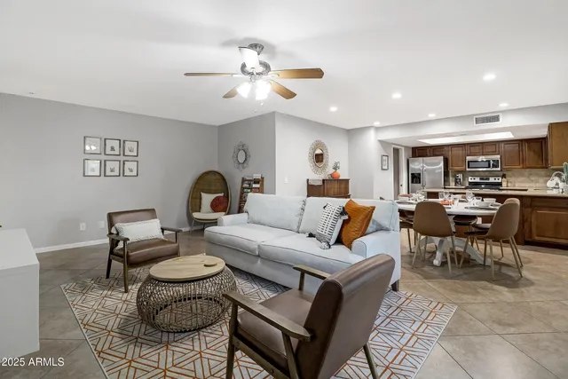 a living room with furniture a table and kitchen view