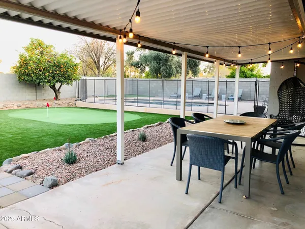a backyard of a house with table and chairs