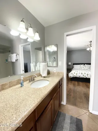 a bathroom with a granite countertop sink and a mirror