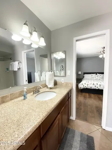 a bathroom with a granite countertop sink and a mirror