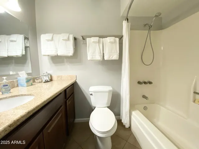 a bathroom with a granite countertop toilet sink and tub