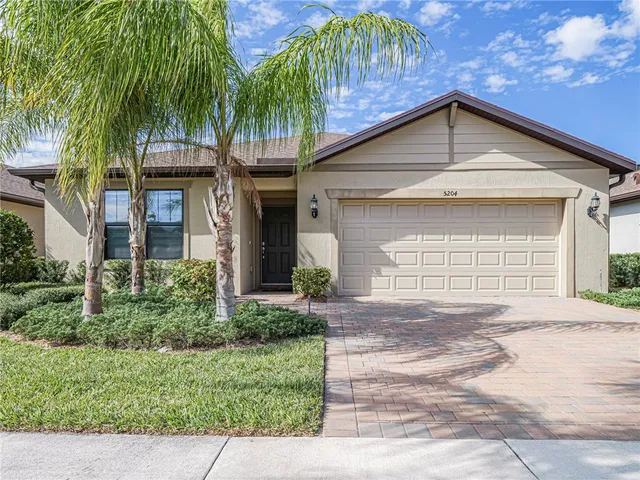 an empty room with wooden floor chandelier and windows