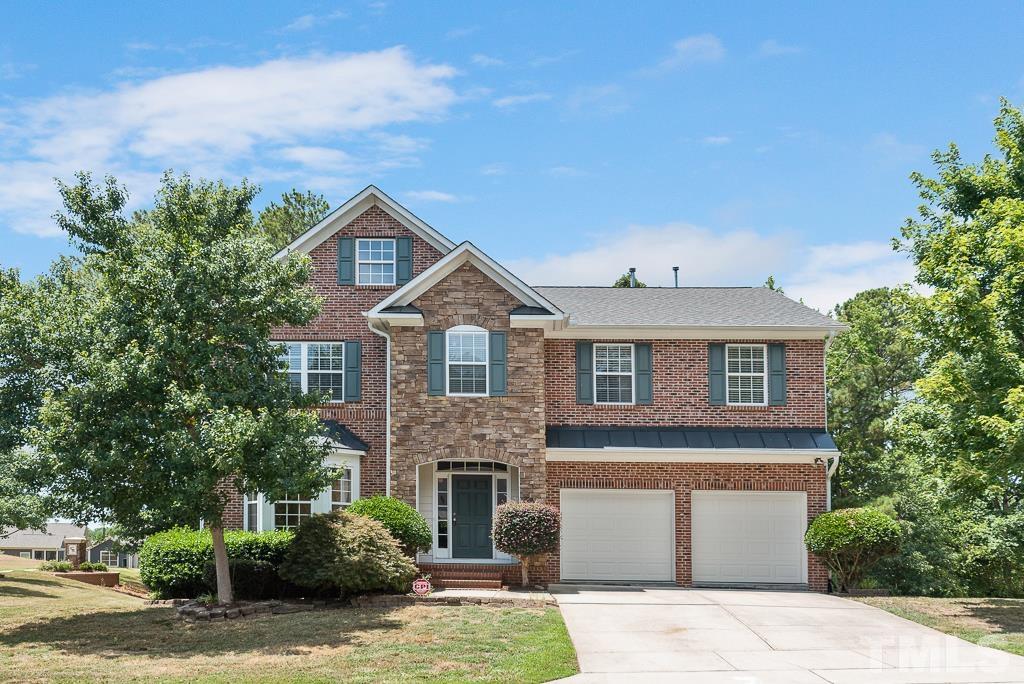 a front view of a house with a yard and garage