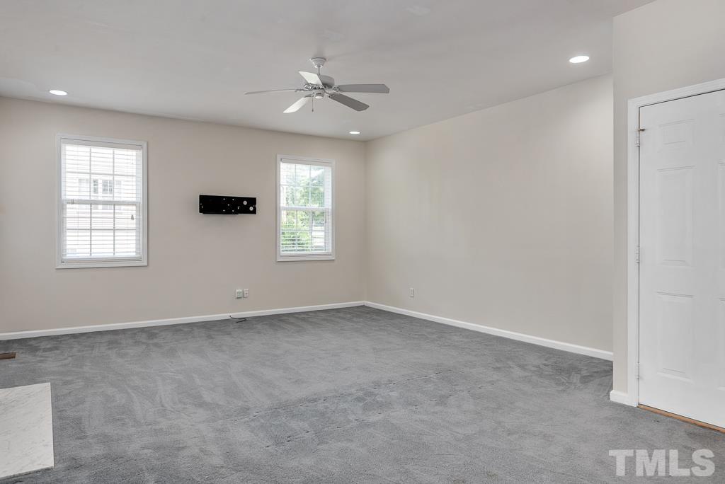 110 Castlebar Lane Durham, NC 27713 - Photo 14 of 32 an empty room with windows and chandelier fan
