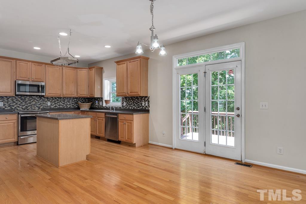 110 Castlebar Lane Durham, NC 27713 - Photo 10 of 32 a kitchen with kitchen island granite countertop a stove top oven a sink and a granite counter top