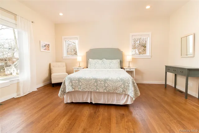 a spacious bedroom with a bed and wooden floor
