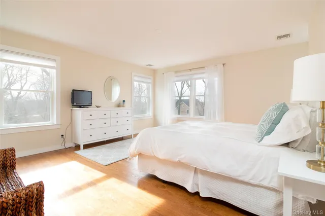 a spacious bedroom with a bed and a chair