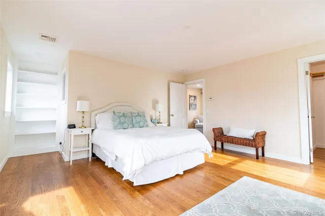 a bedroom with a bed wooden floor and window