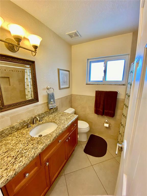 9060 Blind Pass Road, Unit 25 St. Pete Beach, FL 33706 - Photo 12 of 25 a bathroom with a granite countertop sink and a mirror