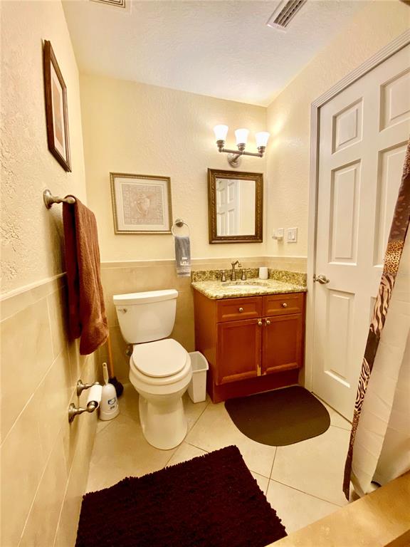 9060 Blind Pass Road, Unit 25 St. Pete Beach, FL 33706 - Photo 14 of 25 a bathroom with a toilet a sink and a mirror