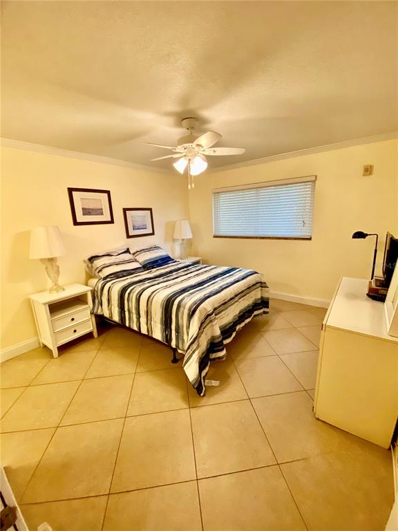 9060 Blind Pass Road, Unit 25 St. Pete Beach, FL 33706 - Photo 18 of 25 a bedroom with a bed and a night stand