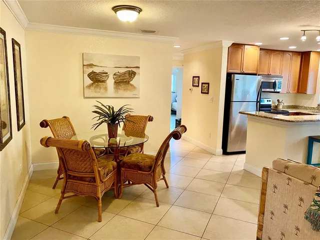 a dining room with stainless steel appliances a dining table and chairs