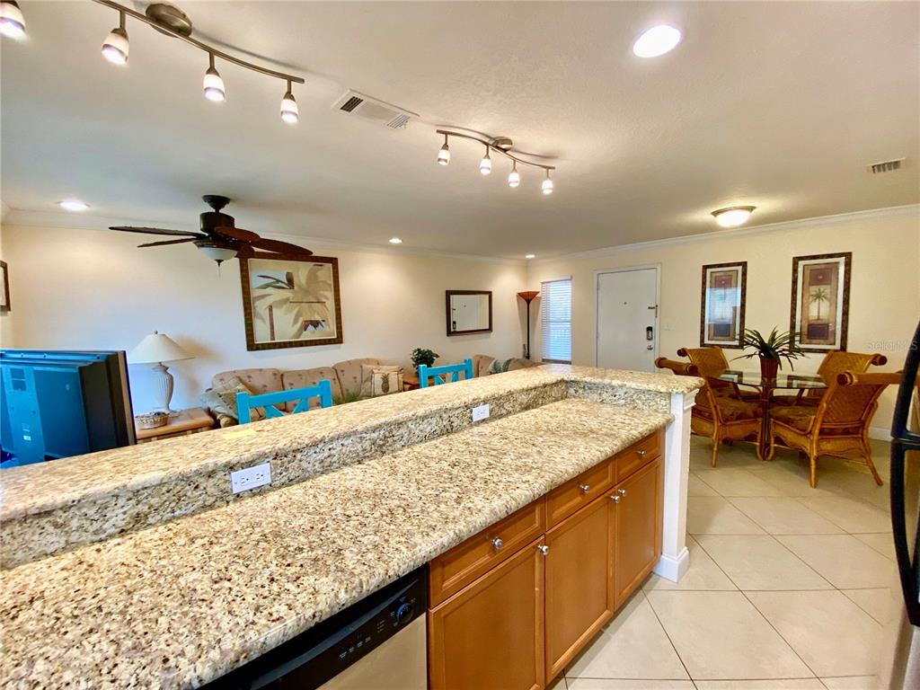 9060 Blind Pass Road, Unit 25 St. Pete Beach, FL 33706 - Photo 8 of 25 a living room with kitchen island furniture and a wooden floor
