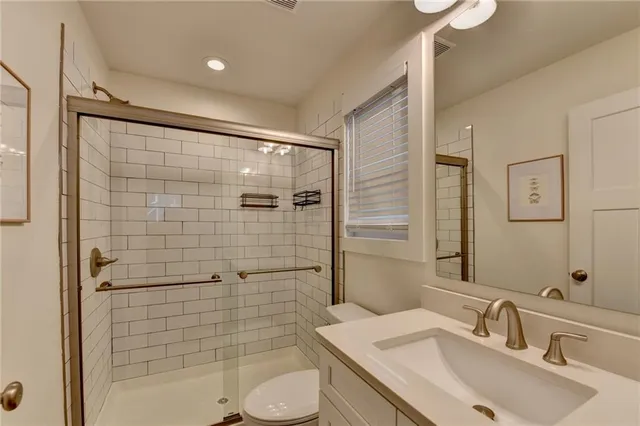 a bathroom with toilet sink shower and mirror